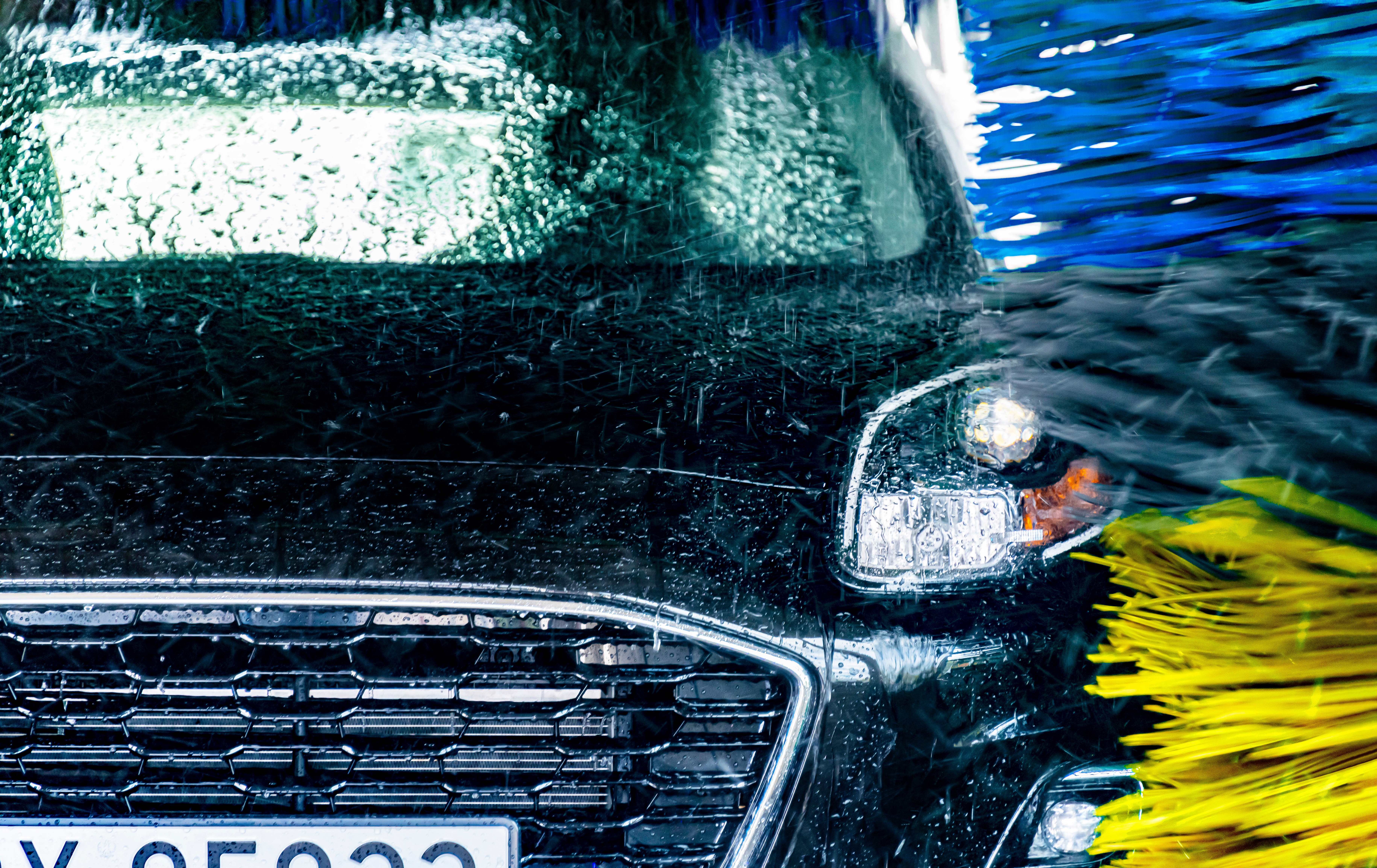 Large brushes cleaning a car.