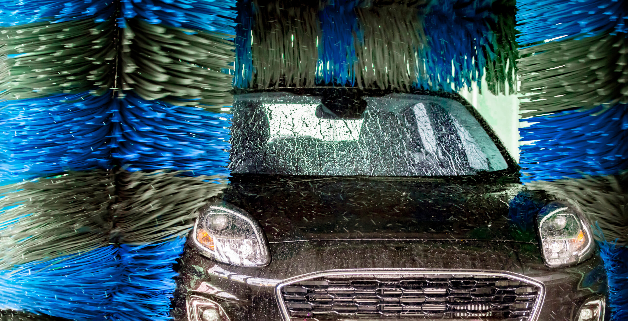 Large brushes cleaning a car.
