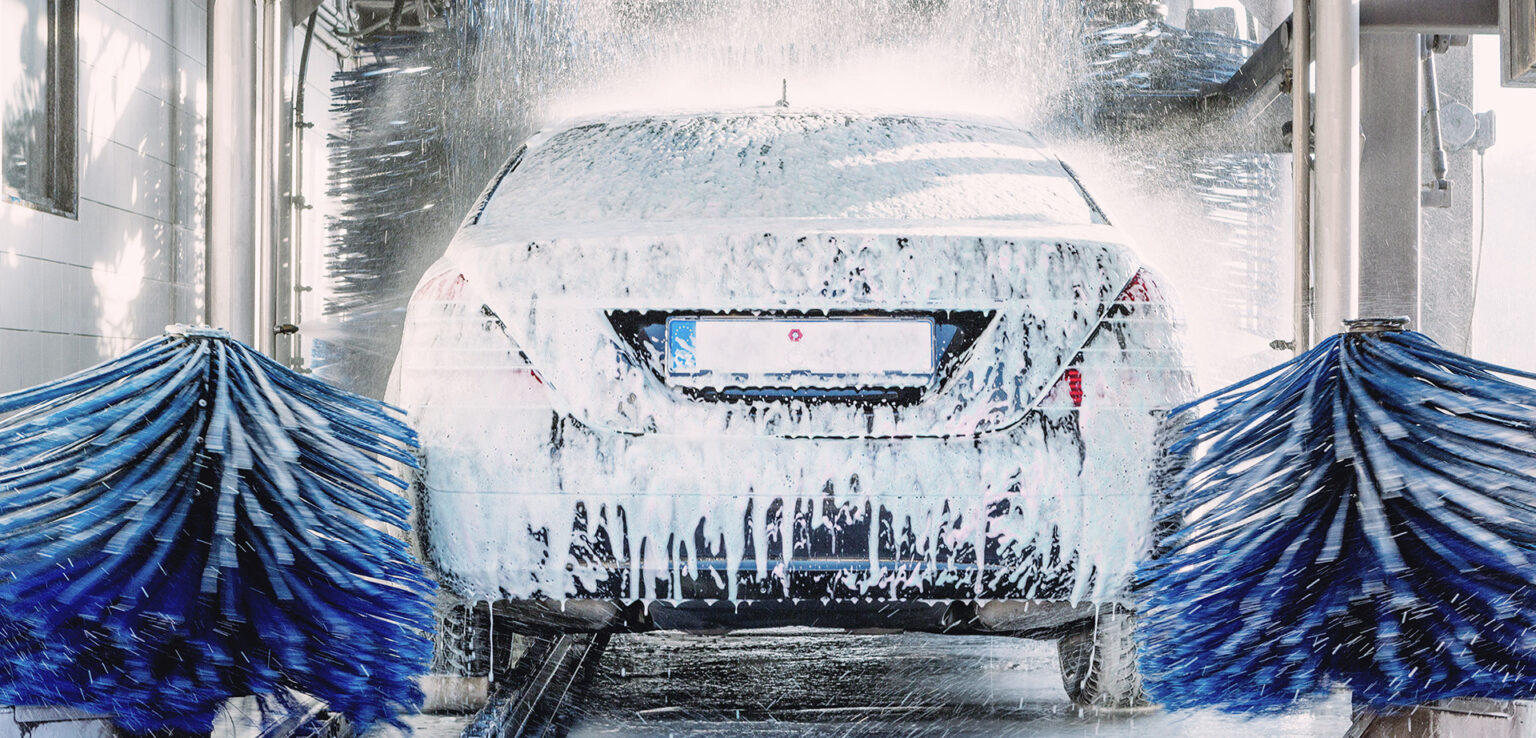 Large brushes cleaning a car.